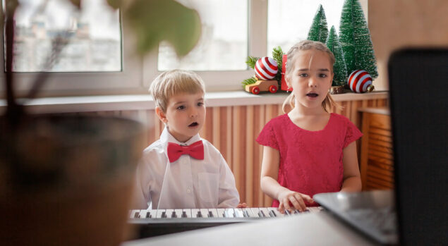 Two children playing the keyboard and singing